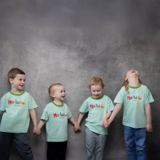 4 kids holding hands wearing children's T-Shirt in Green Organic Cotton with colorful Northbrook Avenue Logo